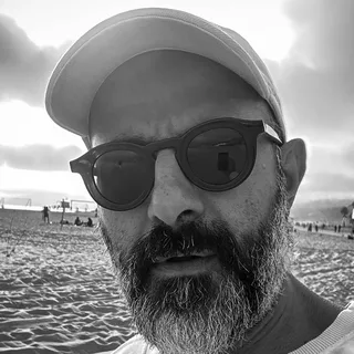 the person who built trippee, on the beach in a cap and sunglasses
